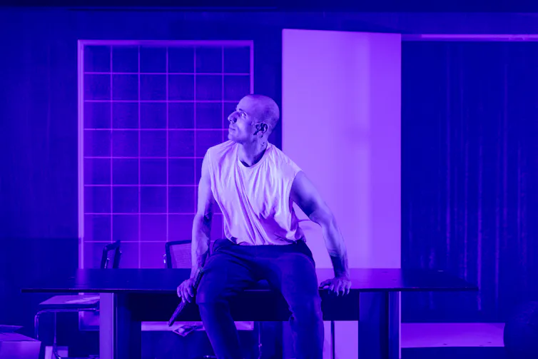 Production image: Nicola bathed in purple light.