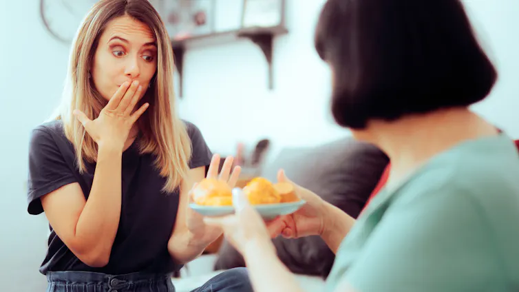 Una mujer rehusa un plato con bollería