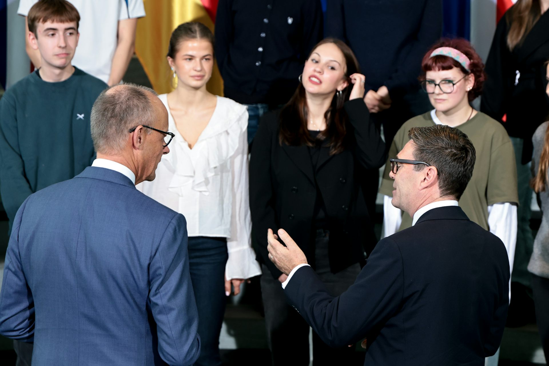 Friedrich Merz and Andy Burnham talk to students at the chancellery in Berlin.