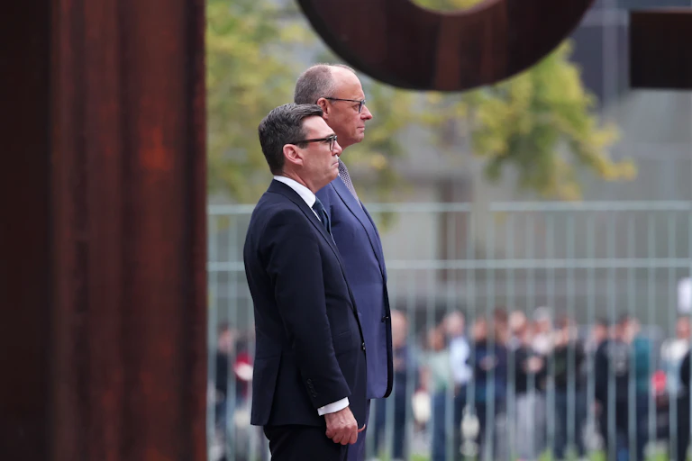 Friedrich Merz and Andy Burnham observe a military ceremony in Berlin.