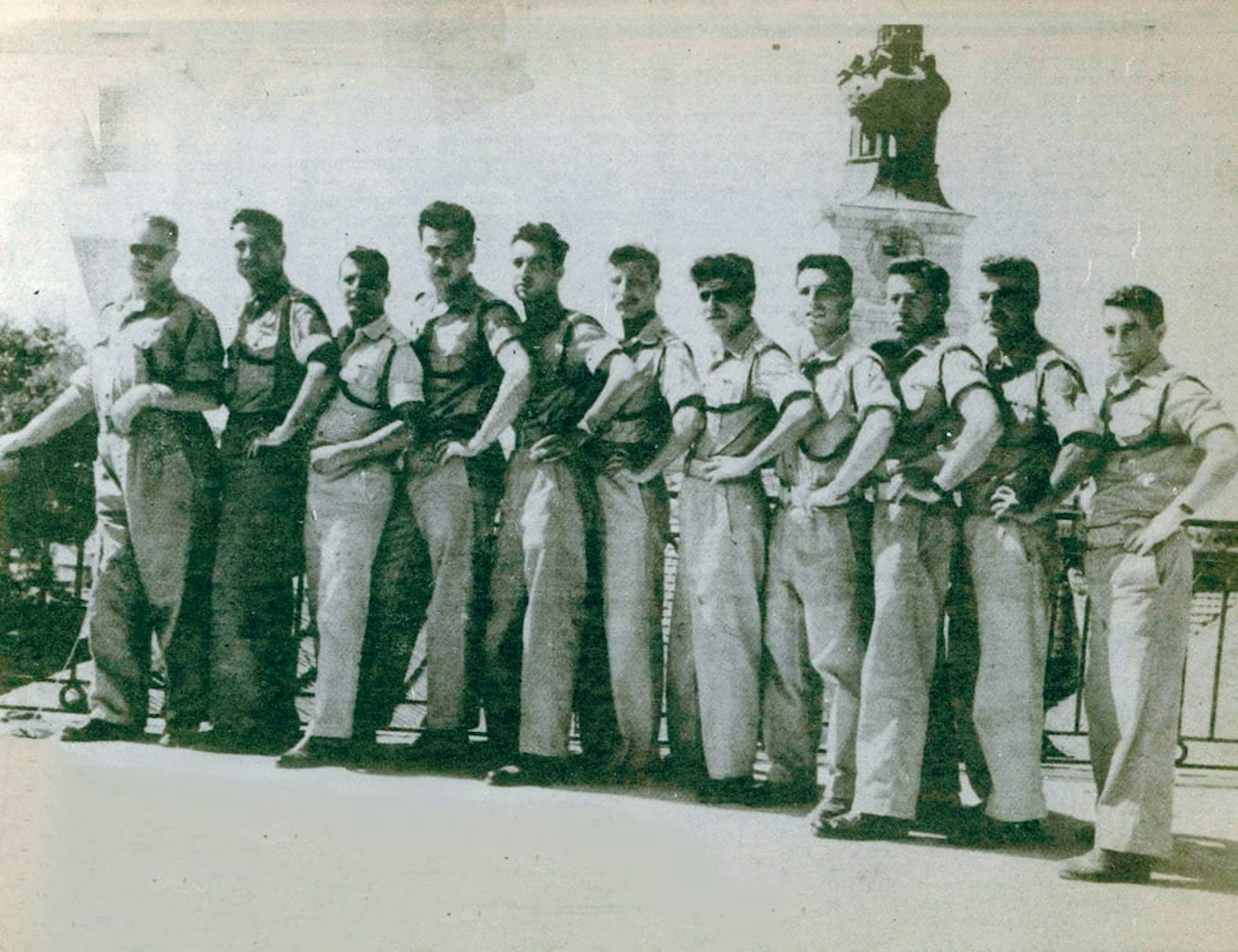 A black and white photo shows a line of men.