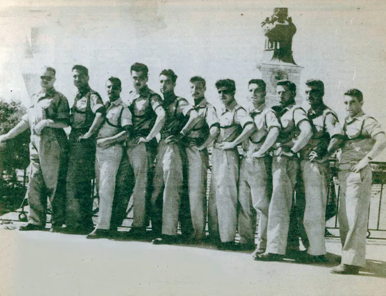 A black and white photo shows a line of men.
