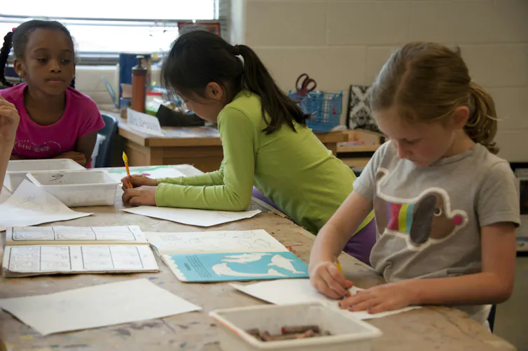 Children drawing at a table in a classroom