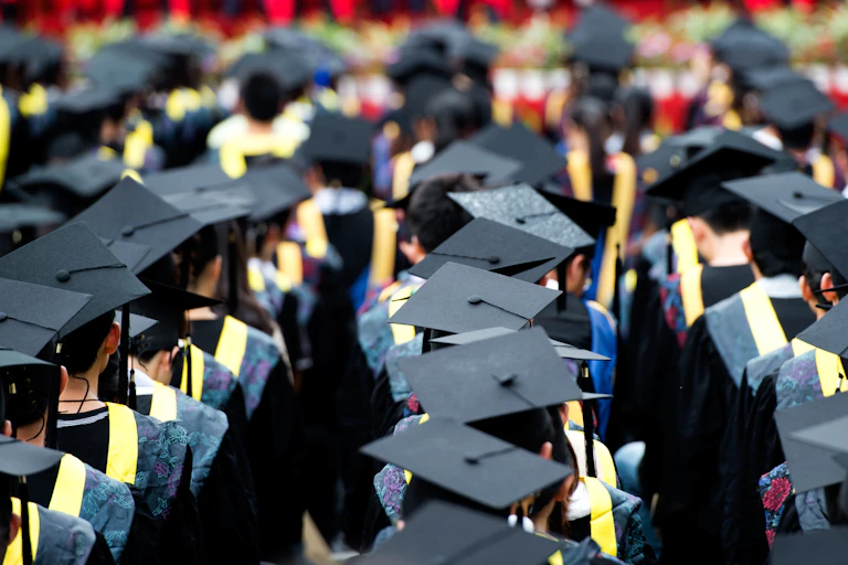 Back view of graduates wearing mortar boards at ceremony