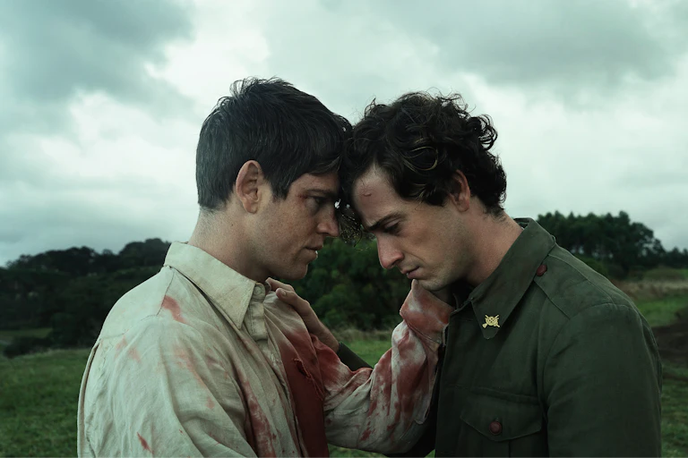 Film still: two men rest their foreheads together.