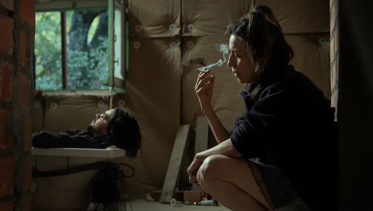Film still: a man in a bath; a woman smokes.