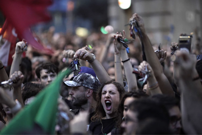 Protesters in Spain hold their house keys in the air as they chant