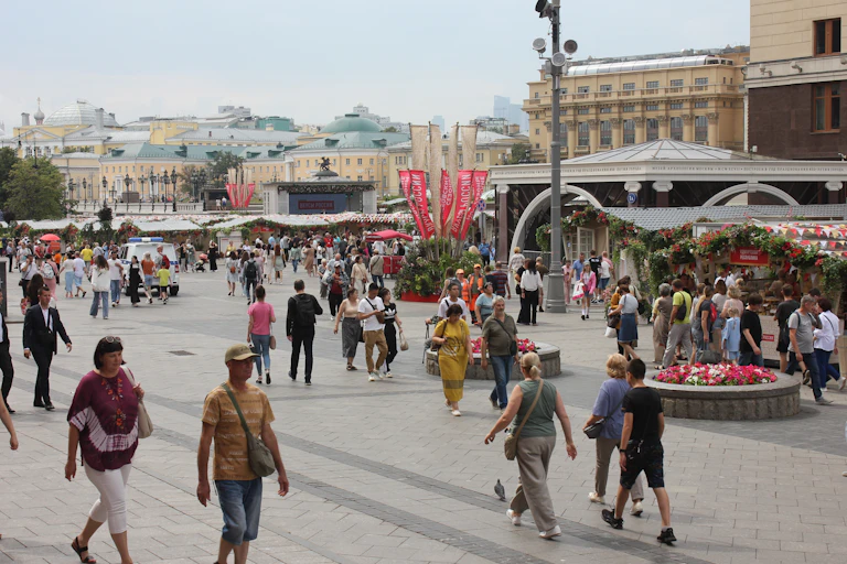A crowd of people walk through a public square in Moscow.