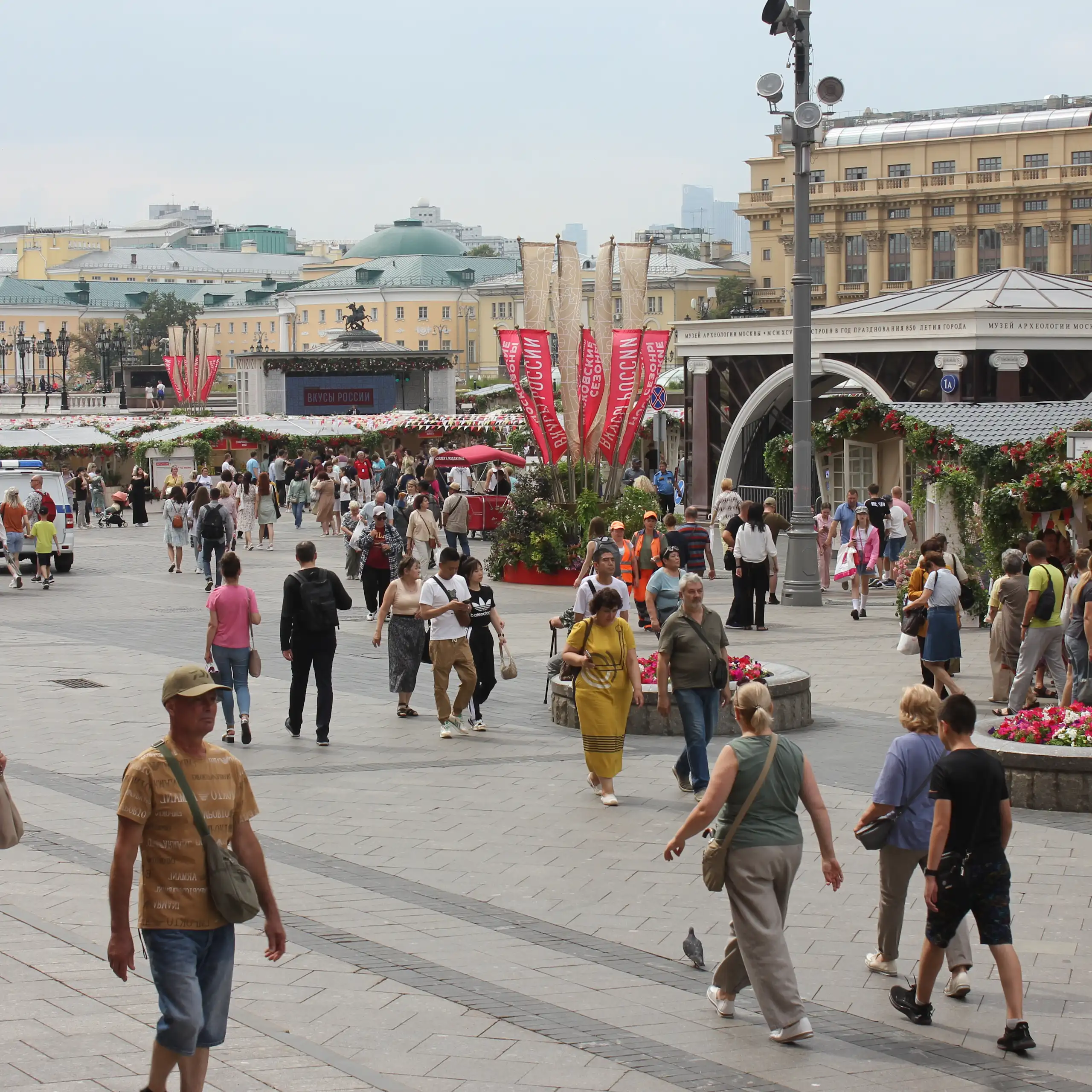 A crowd of people walk through a public square in Moscow.