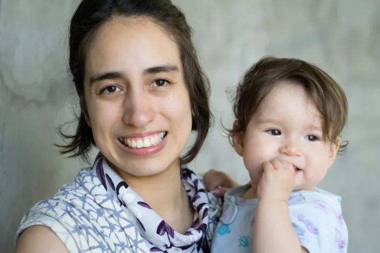 Une femme tient un bébé dans les bras