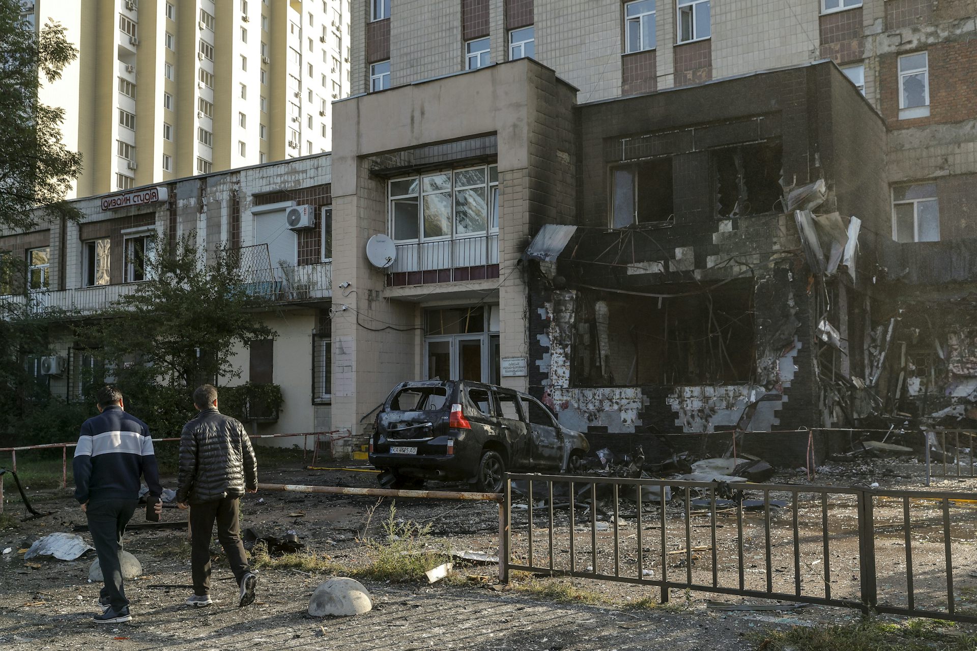 Local residents walk past the site of a Russian strike on a coffee shop in a residential area of Kyiv, Ukraine, 28 September 2026