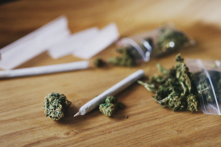 Cannabis and 'spliffs' on a wooden table top.
