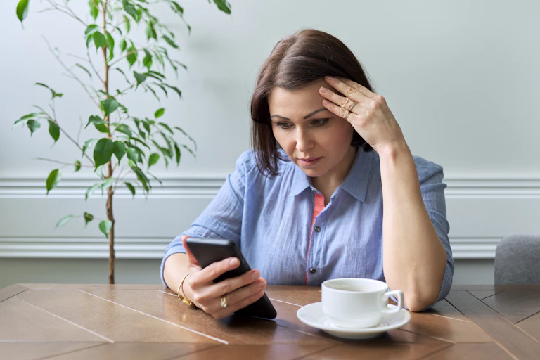 A woman is focused on her phone screen where she follows videos, chats, social networks, etc.