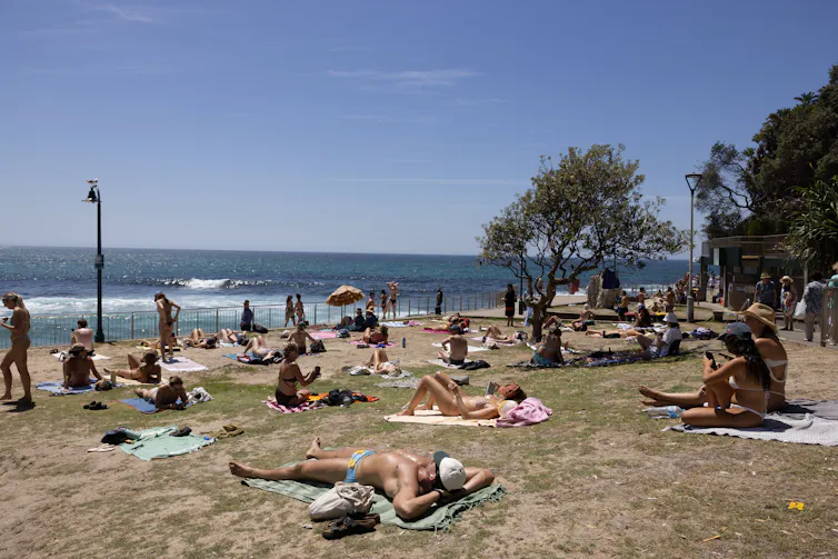 People sun bake during a heatwave at a Sydney beach.