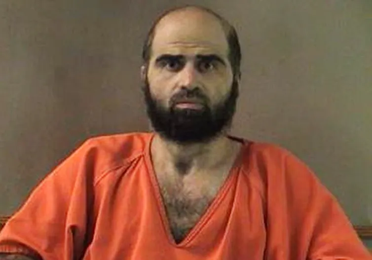 A bearded man in an orange jumpsuit.
