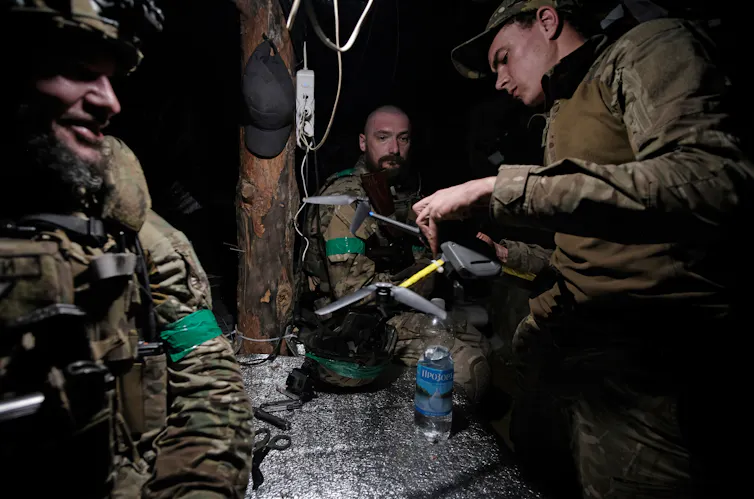Ukrainian soldiers prepare a drone.