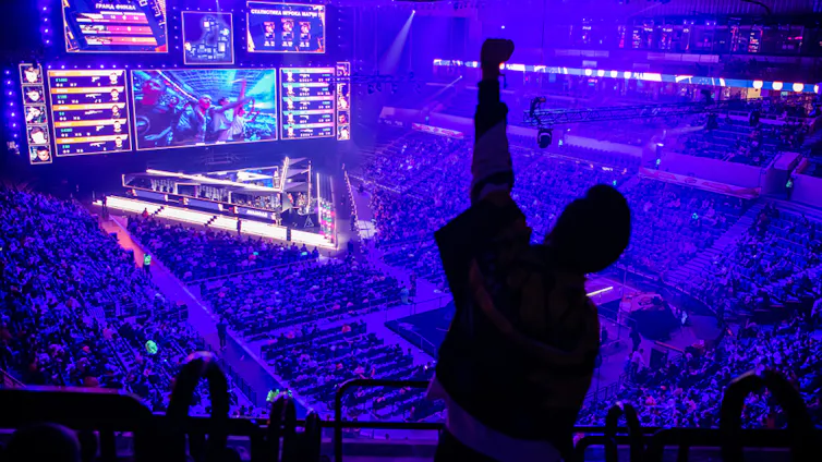 A fan punches the air from the stands during an Esports event.