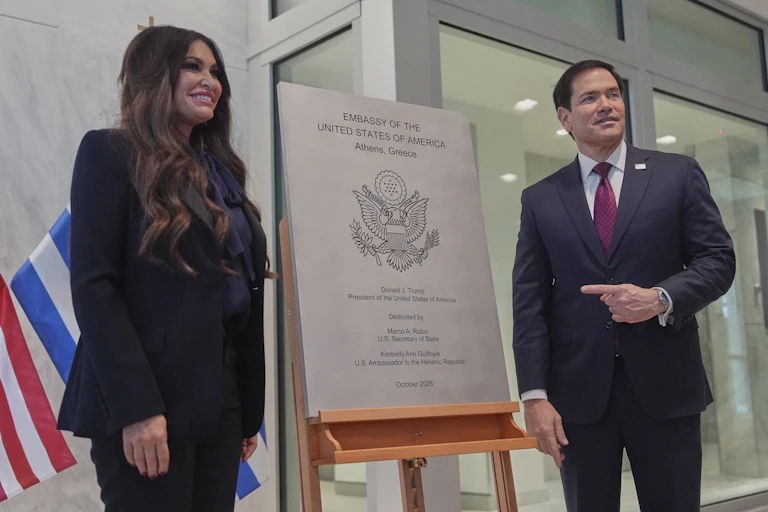 A man and woman stand either side of a plaque.