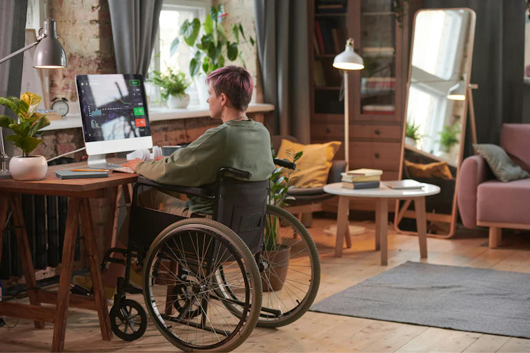 A person in a wheelchair works at a desk