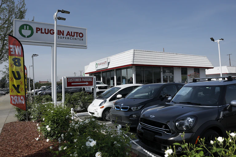 A sales lot for used electric cars has several models on display.