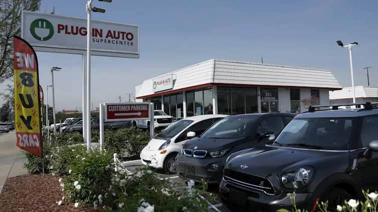 A sales lot for used electric cars has several models on display.