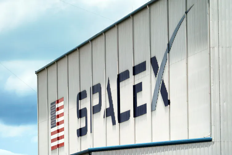 A building with an American flag on the side and a SpaceX logo