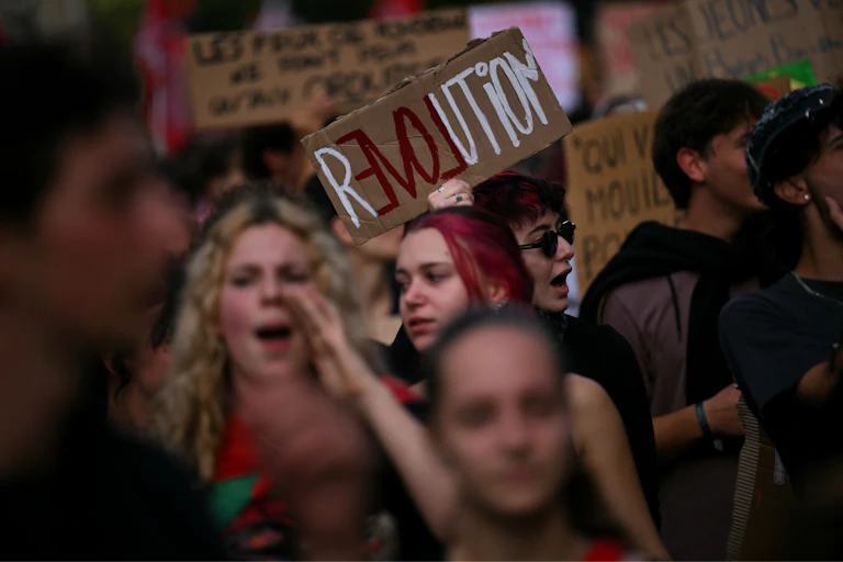 Gros plan sur une jeune fille dans le cortège qui tient une pancarte : « Révolution »