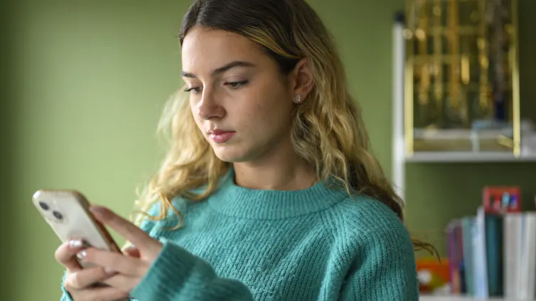 Teen girl looks at her phone.