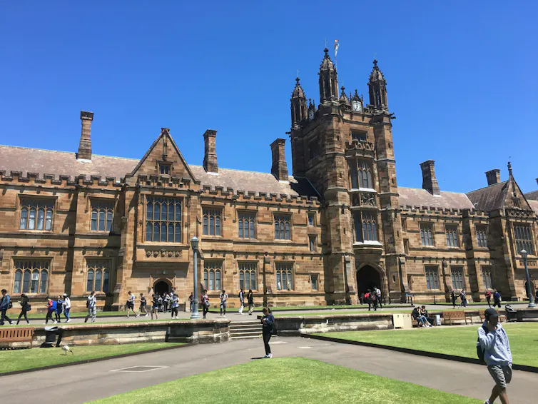 A photograph of a building at University of Sydney, with a person walking away from it.