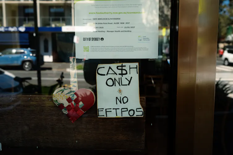 A cash only sign is seen at the front of a shop in Glebe, Sydney,
