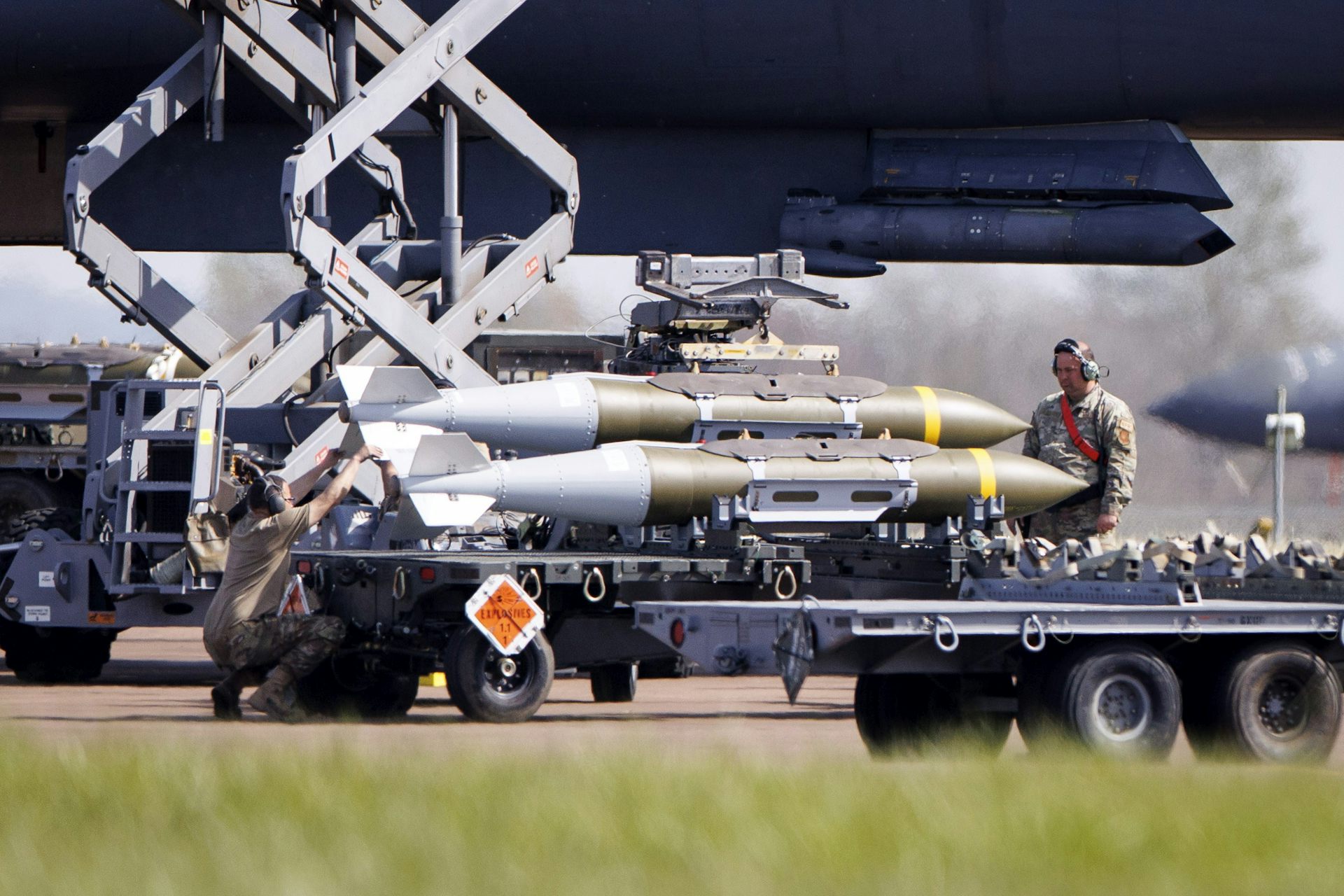 US Air Force military personnel standing next to munitions on the tarmac at RAF Fairford.