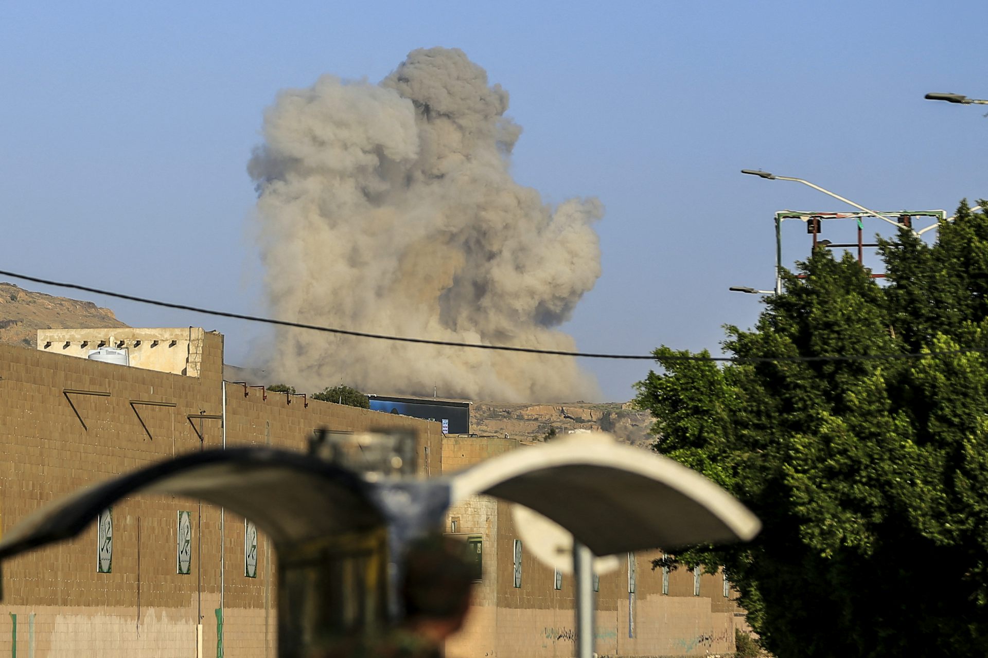 A plume of smoke rises above a building.