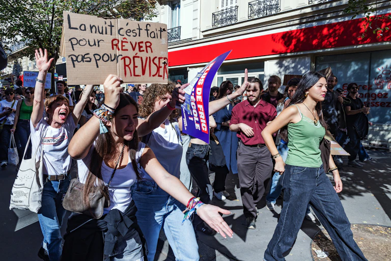 At a high school student demonstration in Paris, young people hold up a sign on which is written: "Night time is for dreaming not revising."