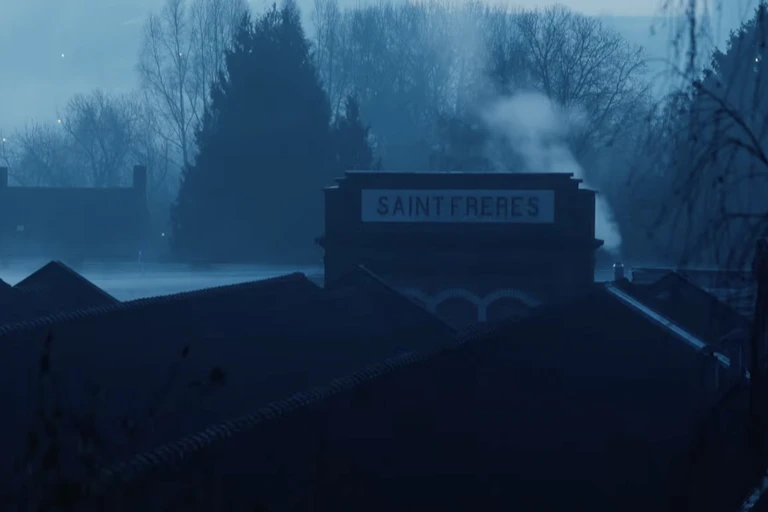 Dans la brume du petit matin, les toits d'une usine Saint-Frères