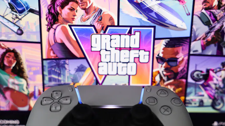 A game controller with game theft auto 6 cover art in the background