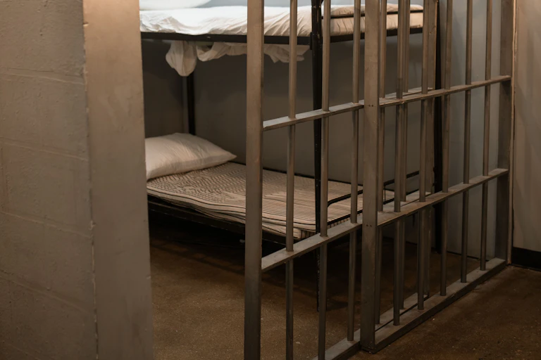 An empty bed in a jail cell.