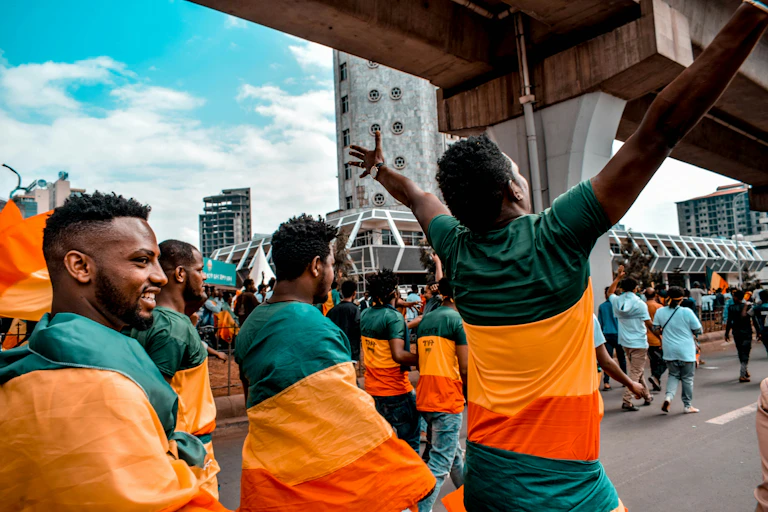 A group of men walking on a street wearing T-shirts with the Ethiopian flag colours