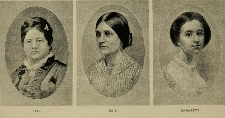 Three austere-looking Victorian women dressed in black.