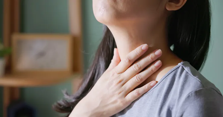 Close-up of person holding hand to their neck