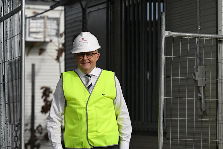 Anthony Albanese wearing a hard hat and a high-vis vest, visits a future housing site in Canberra.