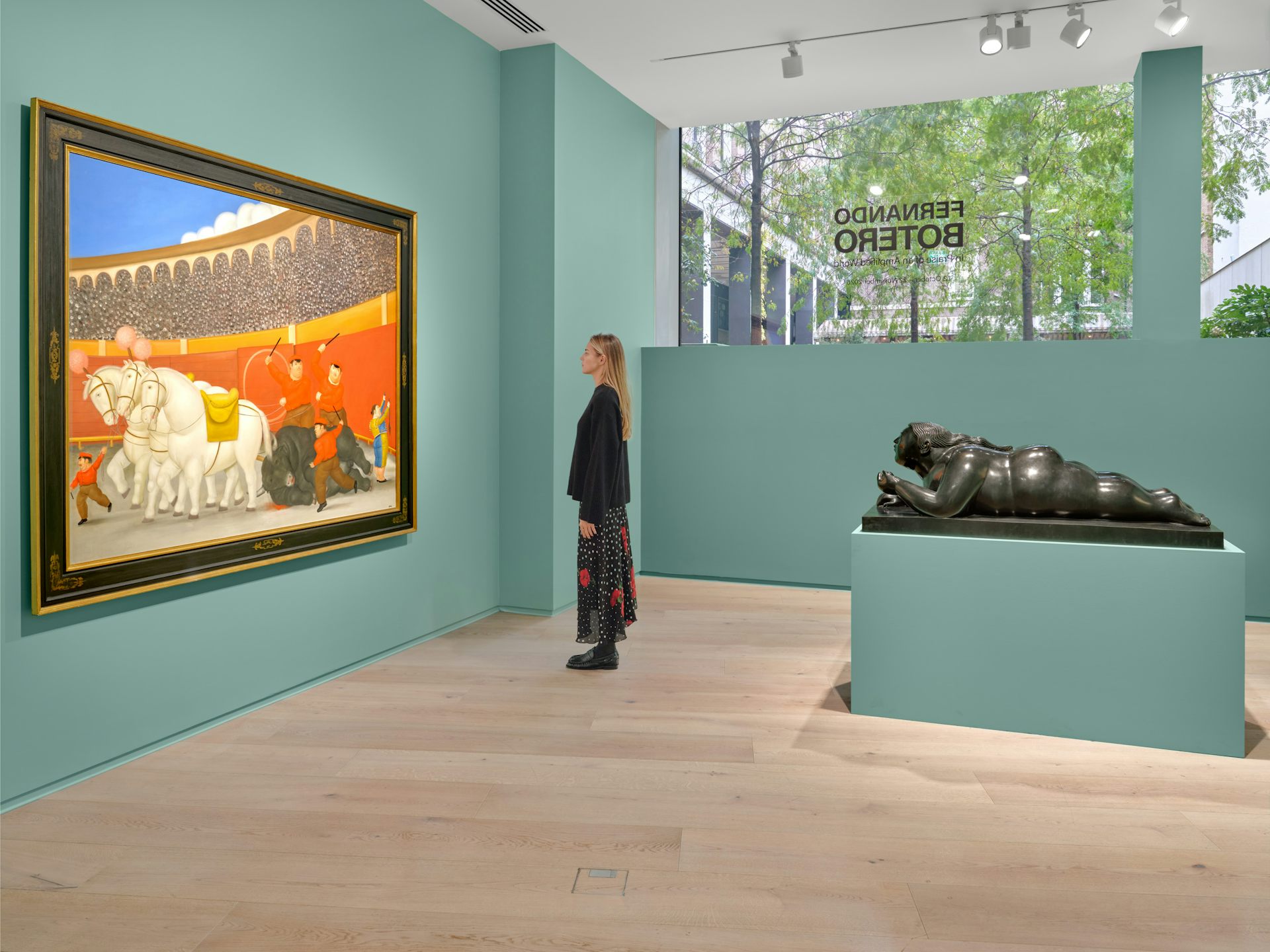 A woman looking at a large painting in the gallery