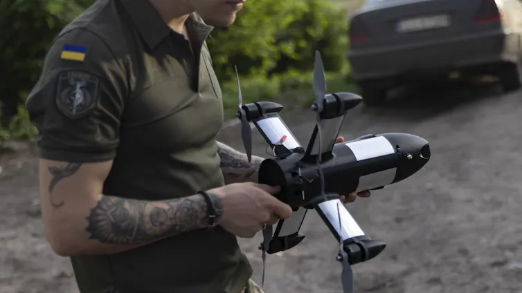 A serviceman of the 116th Mechanized Brigade holds a Ukraine-made P1-Sun interceptor, used to bring down Russian Shahed drones.