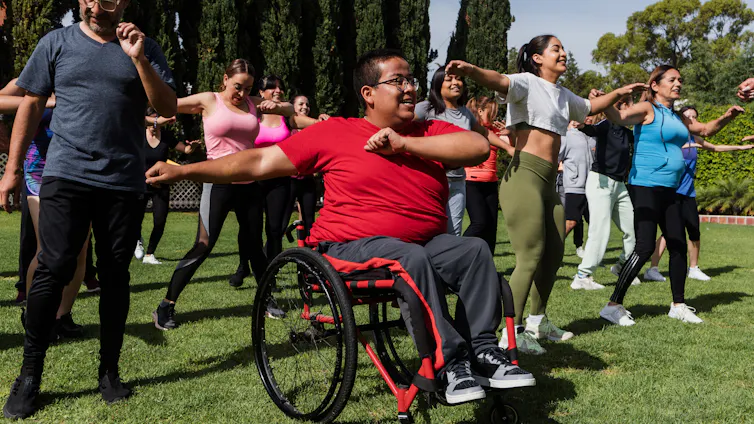 Person in a wheelchair taking part in an outdoor exercise class