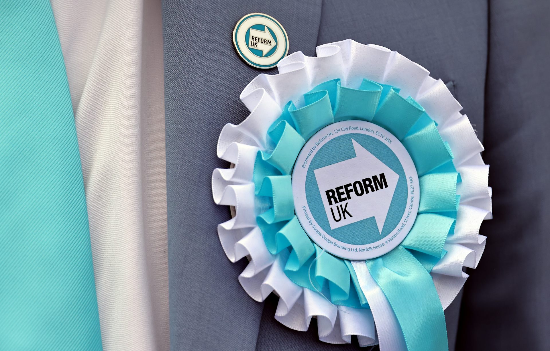 A Reform UK candidate's rosette and badge.