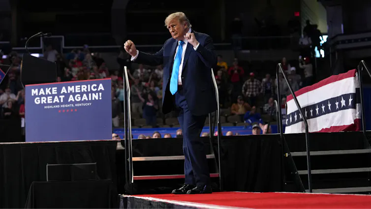 President Donald Trump dances on a stage at a campaign rally in Kentucky on Oct. 17, 2026, next to a 'Make America Great Again' sign.
