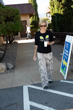 Woman walking from a sidewalk to a parking lot.