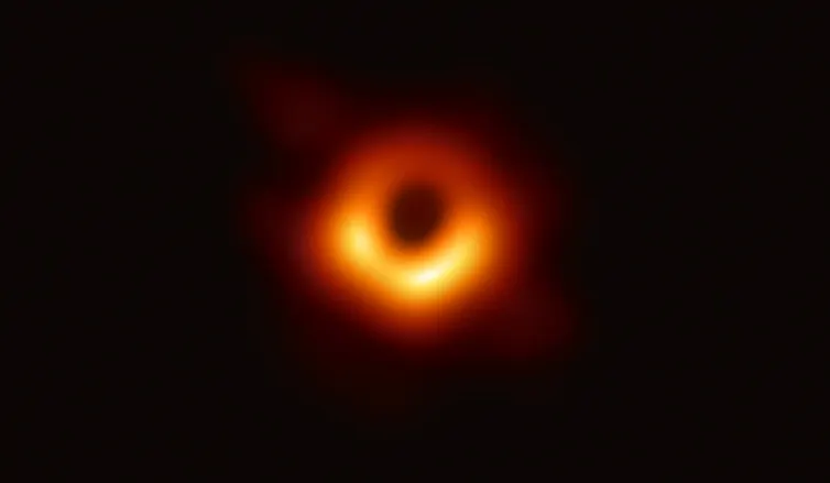 A thick orange blurry circle with a bright yellow blob at the bottom, against a black background.
