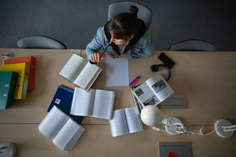Photo from above of young woman studying