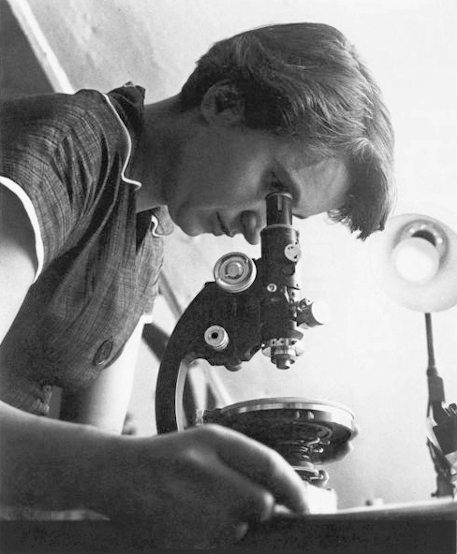 Rosalind Franklin using a microscope.