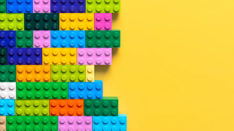 lego bricks colourful on left side, yellow background on right side
